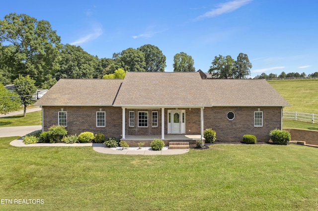 ranch-style home featuring covered porch and a front lawn