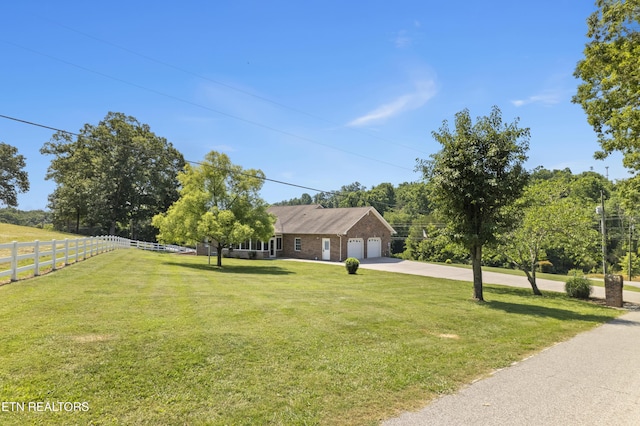 single story home with a garage and a front lawn