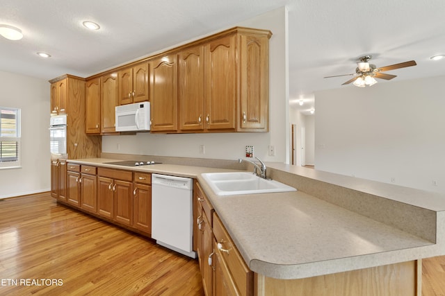 kitchen with white appliances, light hardwood / wood-style floors, sink, kitchen peninsula, and ceiling fan