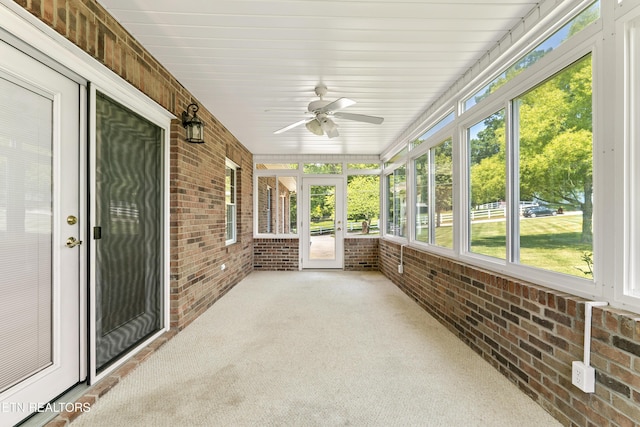 unfurnished sunroom with ceiling fan