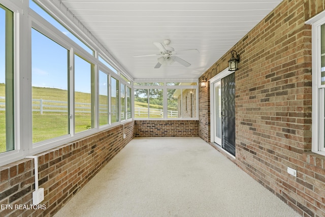 unfurnished sunroom with ceiling fan