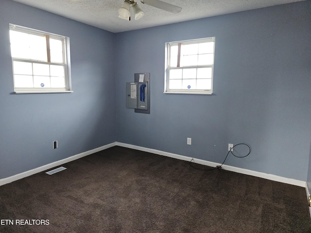 carpeted empty room featuring a textured ceiling, electric panel, and ceiling fan