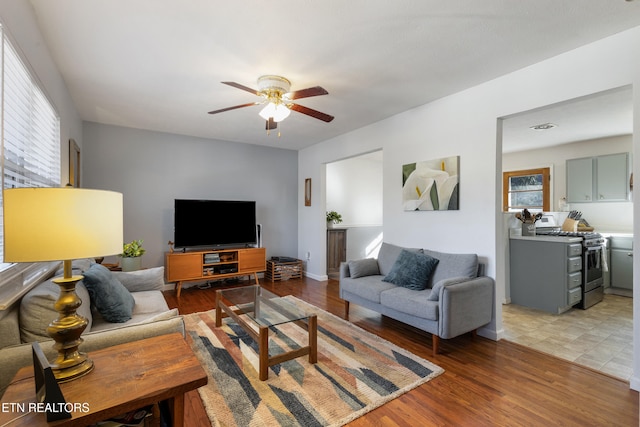 living room featuring ceiling fan, a wealth of natural light, and light wood-type flooring