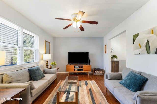 living room featuring dark wood-type flooring and ceiling fan