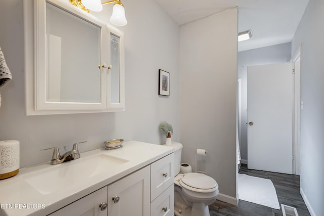 bathroom featuring hardwood / wood-style flooring, vanity, and toilet