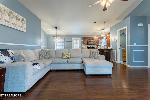 living room with dark hardwood / wood-style flooring and ceiling fan with notable chandelier