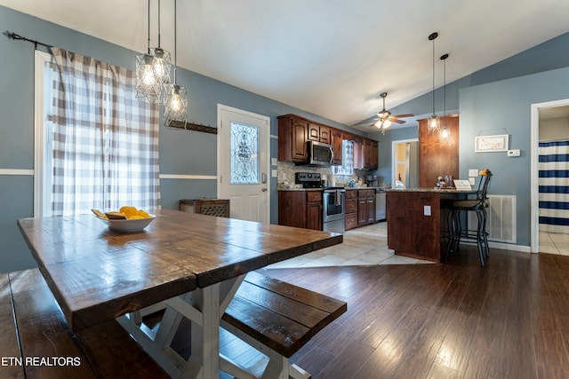 dining room featuring lofted ceiling, ceiling fan, and light wood-type flooring