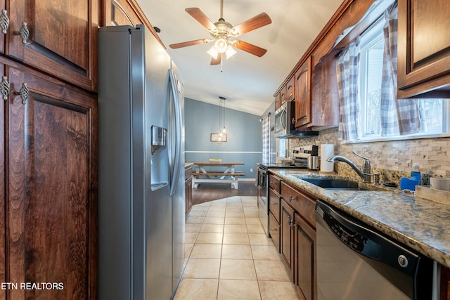 kitchen featuring stainless steel appliances, vaulted ceiling, sink, and backsplash