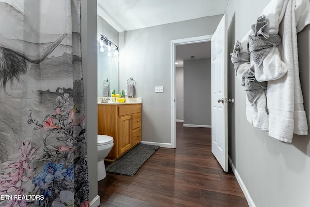 bathroom with vanity, hardwood / wood-style floors, walk in shower, and toilet