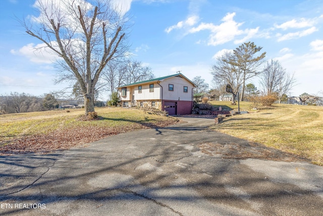 view of side of home featuring a yard and a garage