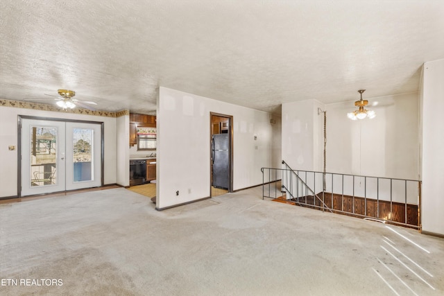 carpeted spare room with ceiling fan with notable chandelier and a textured ceiling