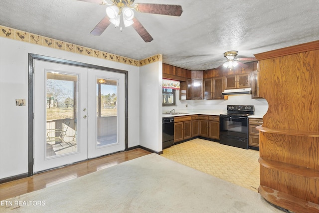 kitchen with light hardwood / wood-style flooring, black appliances, french doors, and a textured ceiling