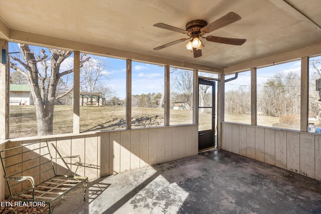 unfurnished sunroom with ceiling fan