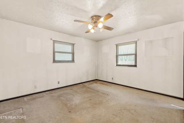 carpeted spare room with ceiling fan and a textured ceiling