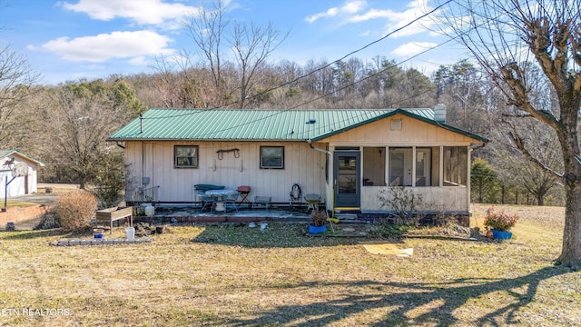 view of front facade with a sunroom and a front lawn