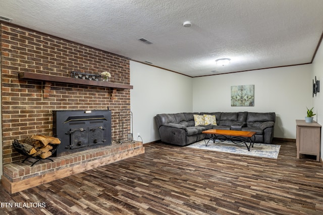 living room featuring dark hardwood / wood-style flooring, ornamental molding, a textured ceiling, and a wood stove