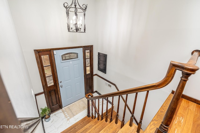 foyer entrance with a chandelier and light hardwood / wood-style floors