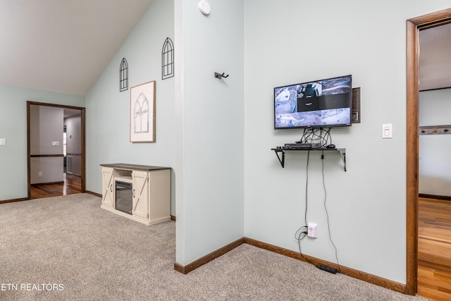 unfurnished living room with high vaulted ceiling and light carpet