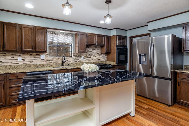 kitchen featuring sink, a center island, light hardwood / wood-style floors, black appliances, and crown molding