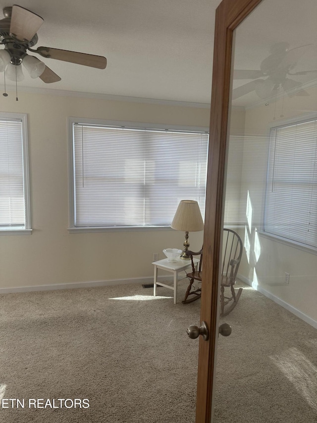 interior space featuring crown molding, carpet floors, and ceiling fan