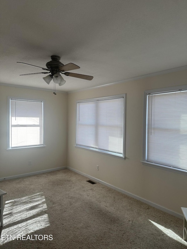 carpeted empty room with crown molding and ceiling fan