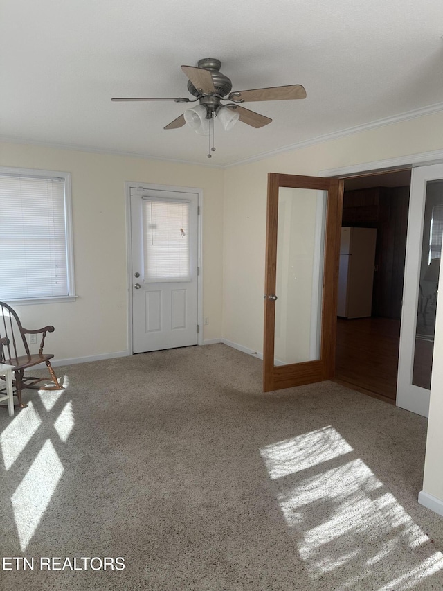 interior space with crown molding, light colored carpet, ceiling fan, and french doors