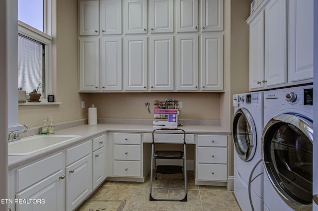 washroom with cabinet space, washing machine and dryer, and a sink