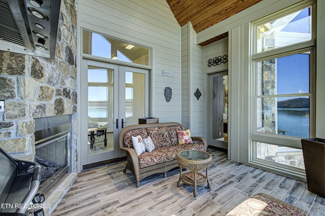 sunroom with wood ceiling, a wealth of natural light, french doors, and vaulted ceiling