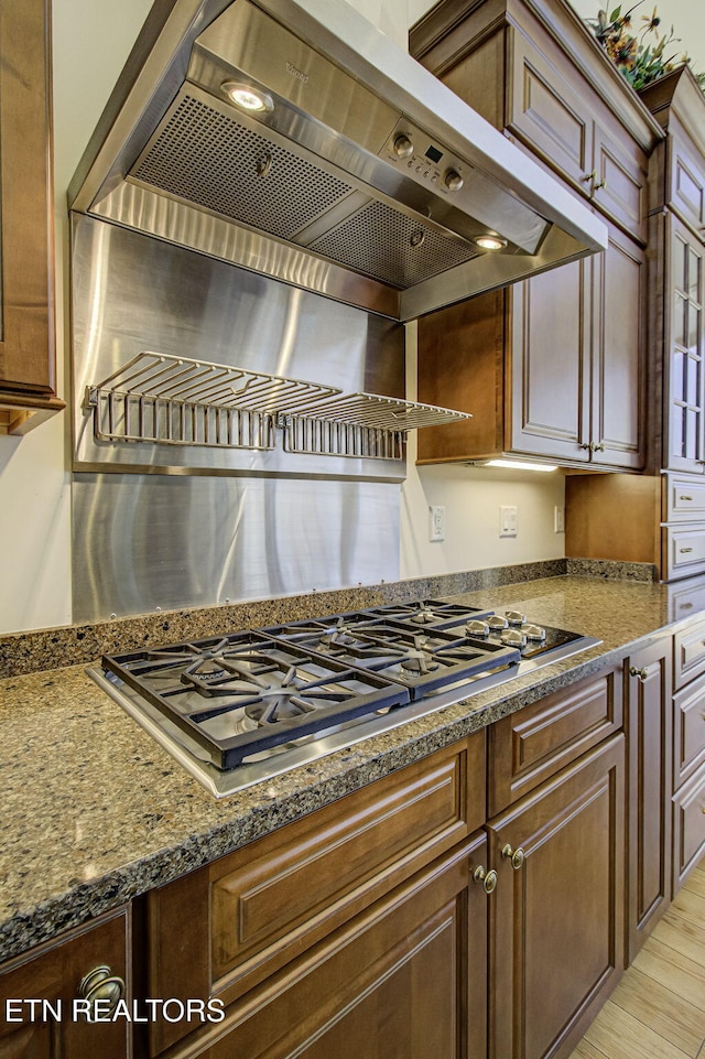 kitchen featuring light wood-style floors, stainless steel gas cooktop, and exhaust hood