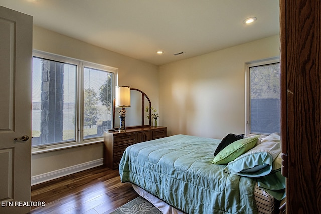 bedroom with dark wood-style floors, recessed lighting, visible vents, and baseboards