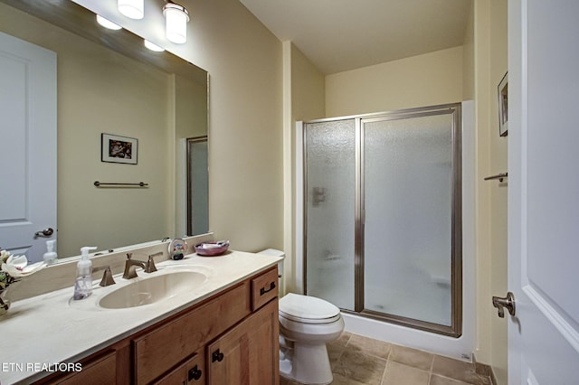 bathroom featuring a stall shower, vanity, toilet, and tile patterned floors