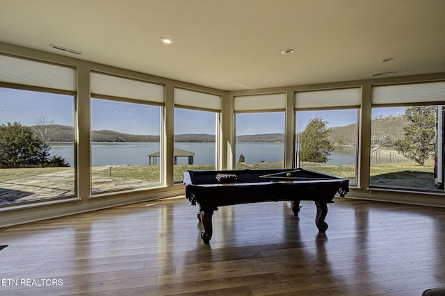 recreation room with recessed lighting, visible vents, a water view, and wood finished floors