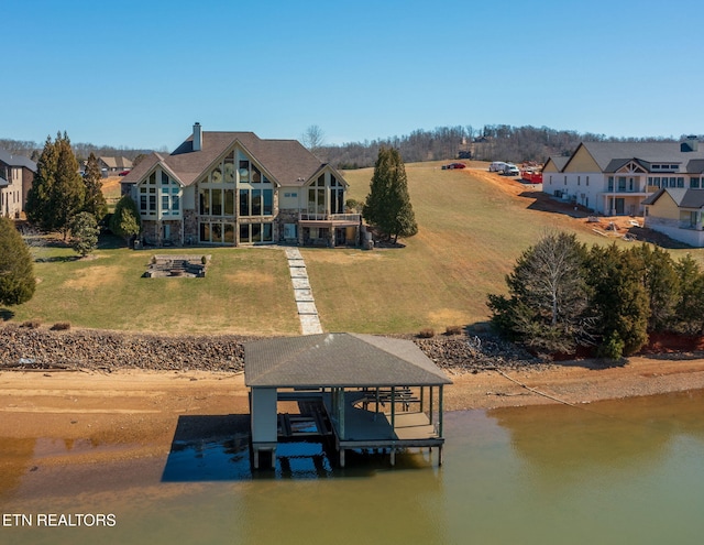 view of dock featuring a lawn, a water view, and boat lift