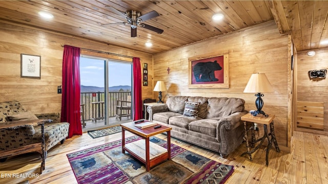 living room with a mountain view, hardwood / wood-style floors, wood ceiling, and wooden walls