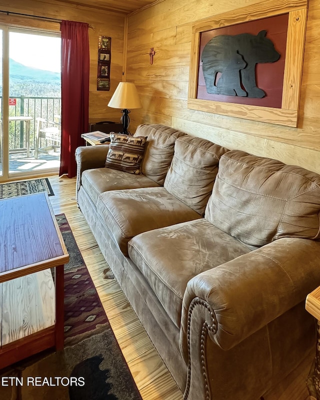 living room with wooden walls, a mountain view, and hardwood / wood-style floors