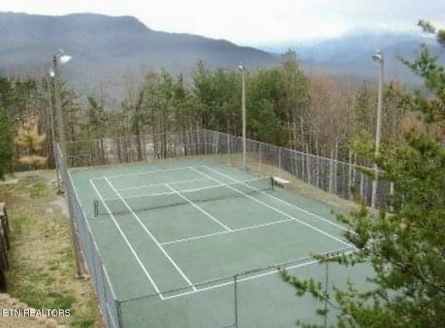 view of tennis court featuring a mountain view