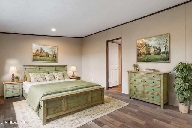 bedroom featuring dark hardwood / wood-style flooring, ornamental molding, and a textured ceiling