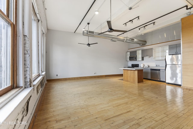 kitchen featuring decorative light fixtures, a center island, light hardwood / wood-style flooring, ceiling fan, and stainless steel appliances