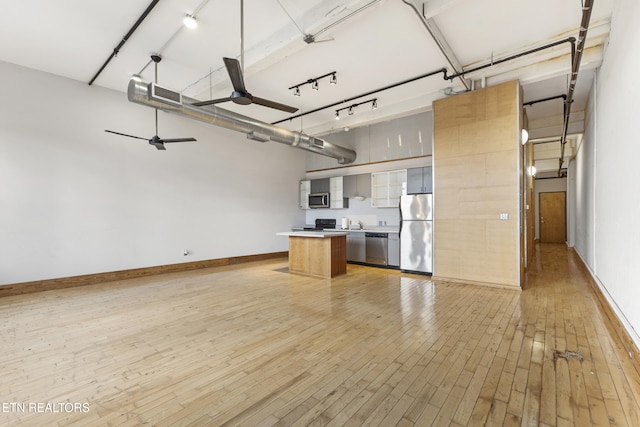 kitchen with stainless steel appliances, a kitchen island, ceiling fan, and light hardwood / wood-style flooring