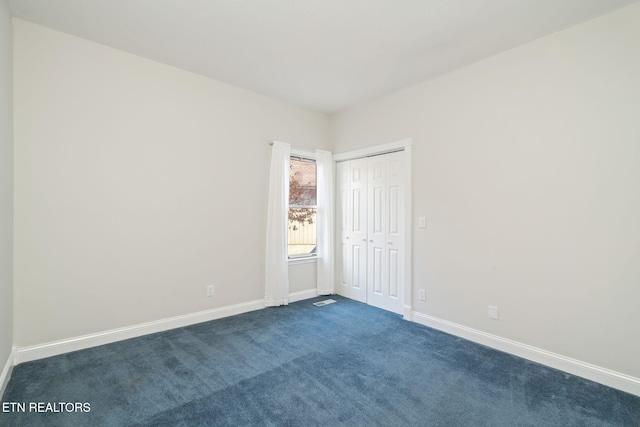 unfurnished room with dark colored carpet