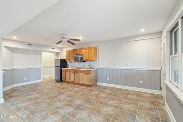 kitchen with appliances with stainless steel finishes, sink, and ceiling fan