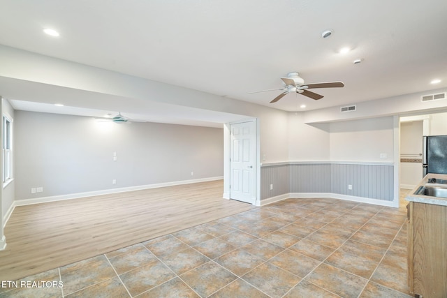 interior space with ceiling fan, wood-type flooring, and sink