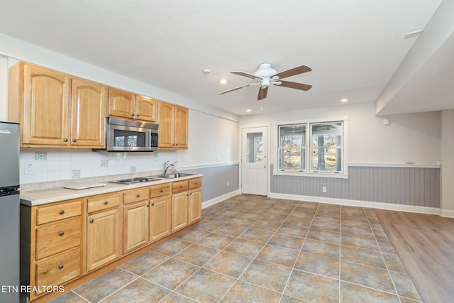 kitchen featuring sink, decorative backsplash, ceiling fan, and appliances with stainless steel finishes