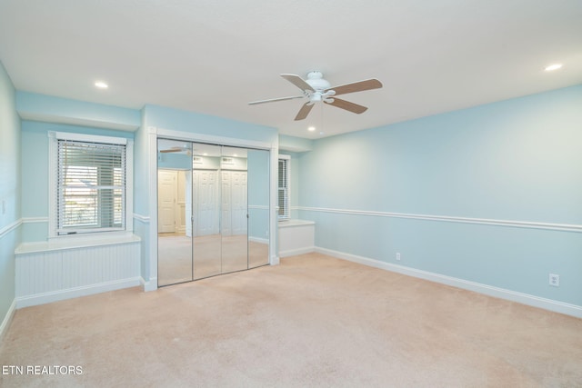 unfurnished bedroom with light carpet, ceiling fan, and a closet