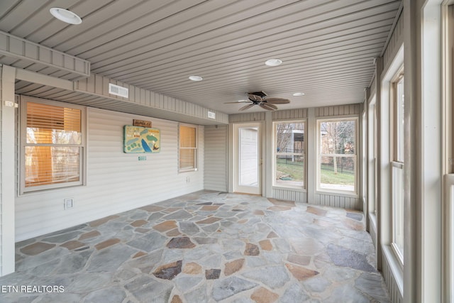 unfurnished sunroom with ceiling fan