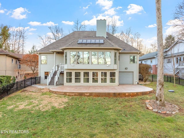 rear view of house with a garage, a yard, and a patio area