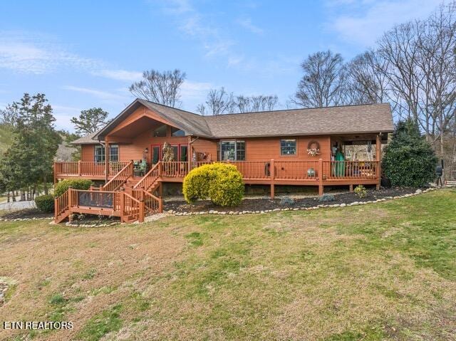 back of house featuring a wooden deck and a lawn