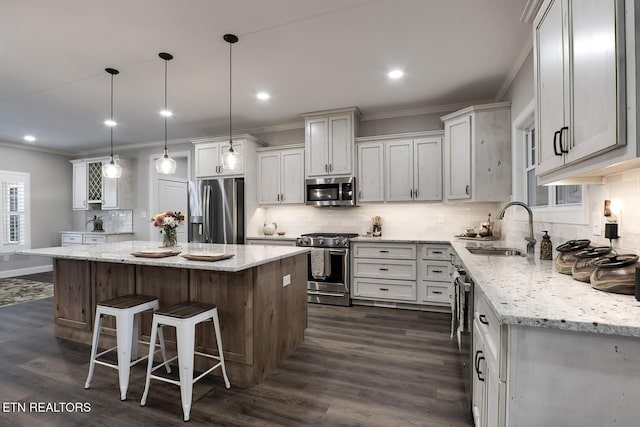 kitchen with appliances with stainless steel finishes, a center island, sink, and decorative backsplash