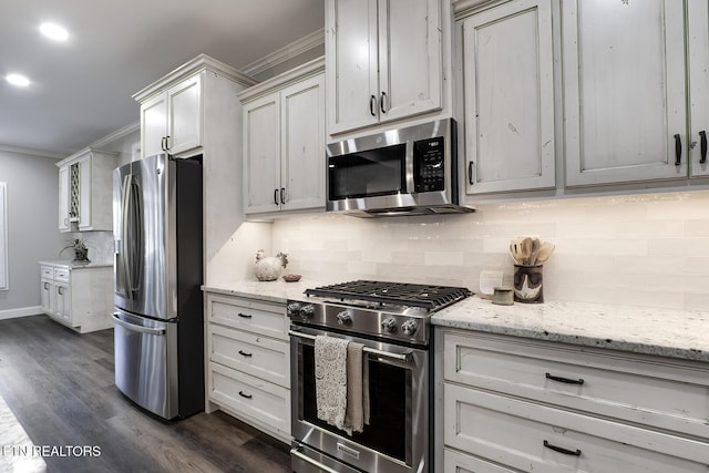 kitchen with light stone counters, decorative backsplash, stainless steel appliances, and dark hardwood / wood-style floors