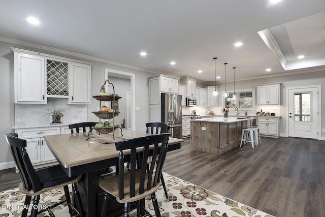 dining room with ornamental molding, dark hardwood / wood-style flooring, and sink